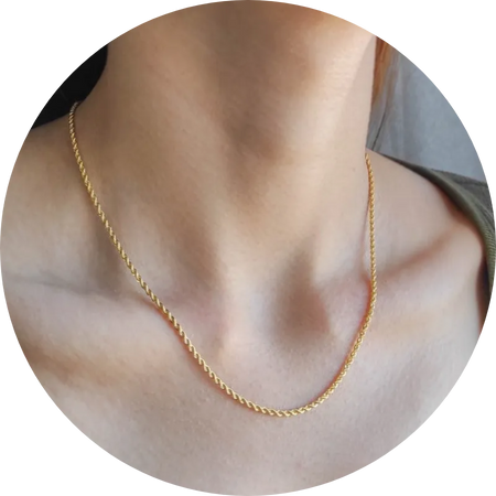 Mujer con una cadena fina de oro de 18k al cuello