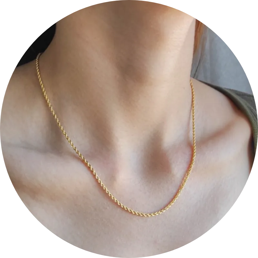 Mujer con una cadena fina de oro de 18k al cuello