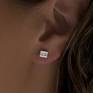 Pendientes botón de plata de ley 925 con línea de tres circonitas blancas, 5mm x 5mm x 3mm.