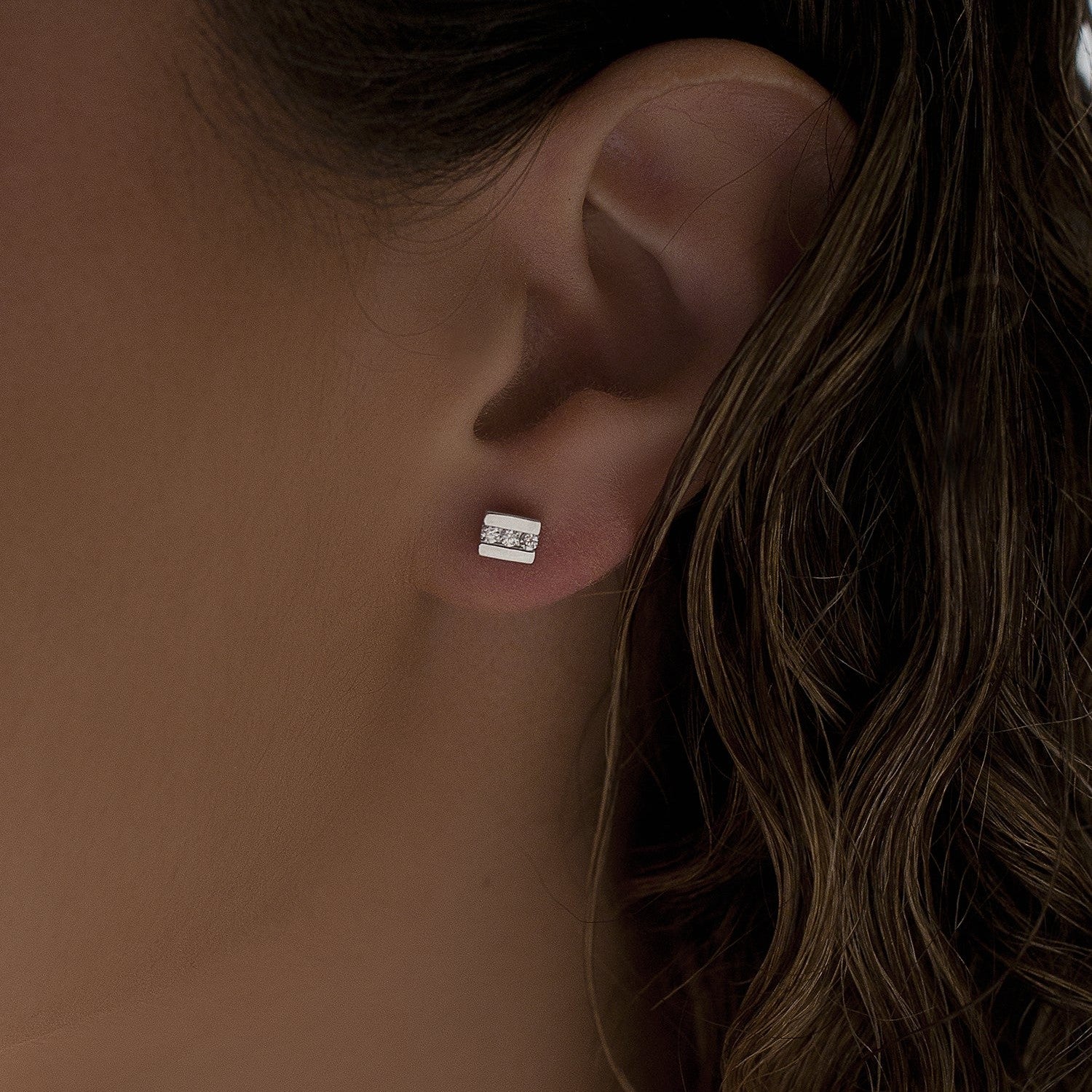 Pendientes botón de plata de ley 925 con línea de tres circonitas blancas, 5mm x 5mm x 3mm.