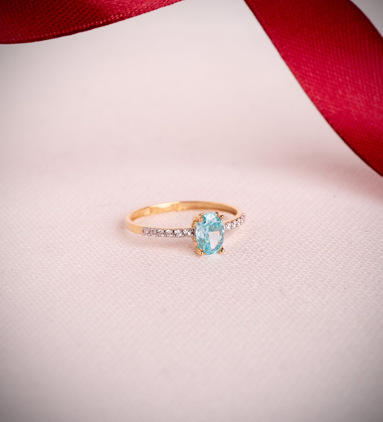 Anillo con topacio paraíba y circonitas en oro 18k bicolor