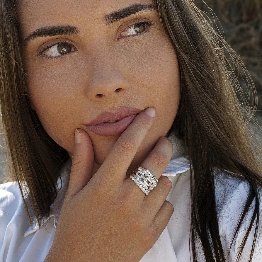 Anillo ancho de plata de ley 925 con diseño entrelazado y circonitas blancas.