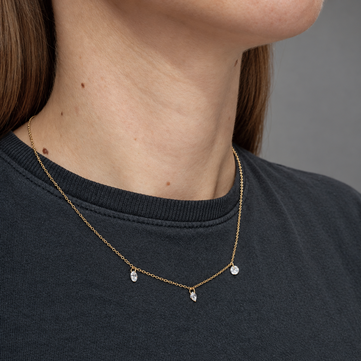 Colgante con tres circonitas en plata de ley 925 con baño de oro, cadena 40+5 cm, puesto en el cuello