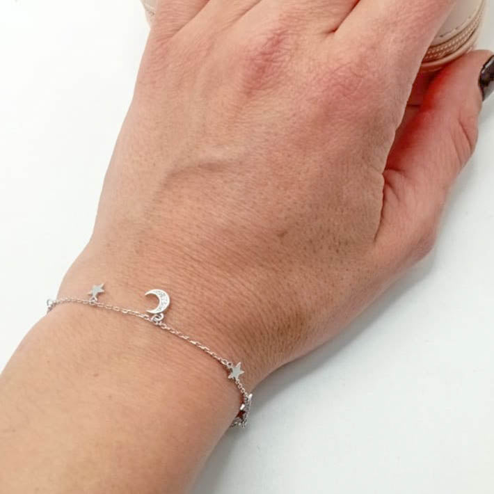 Pulsera de plata fina con estrellas y luna colgando