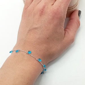 Pulsera de plata fina con circonitas redondas azules colgando foto
