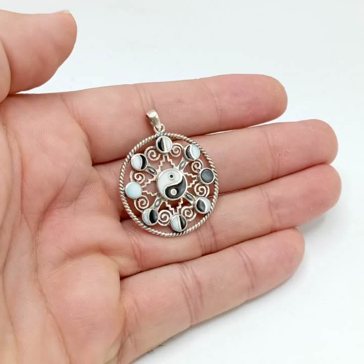 Colgante de plata de ley 925 yin yan con fases lunares sujeto en la mano