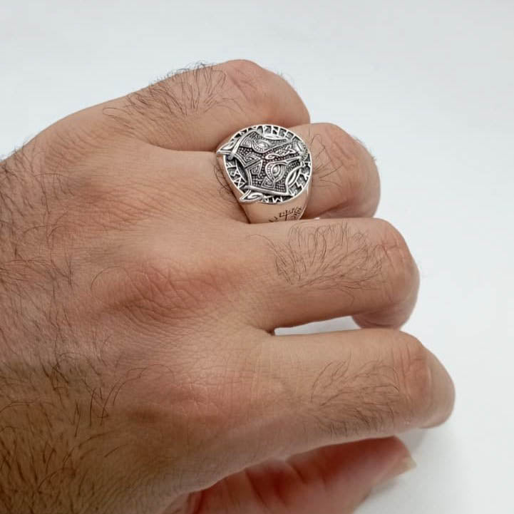 Anillo de plata de ley con runas vikingas y cabeza de lobo puesto en el dedo