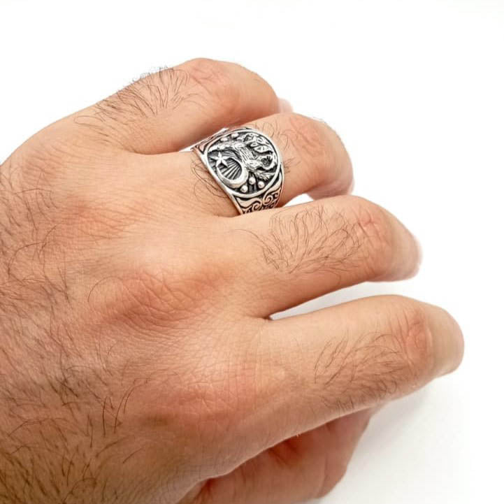 Anillo de plata de ley sello con dibujo de lobo y luna puesto en el dedo