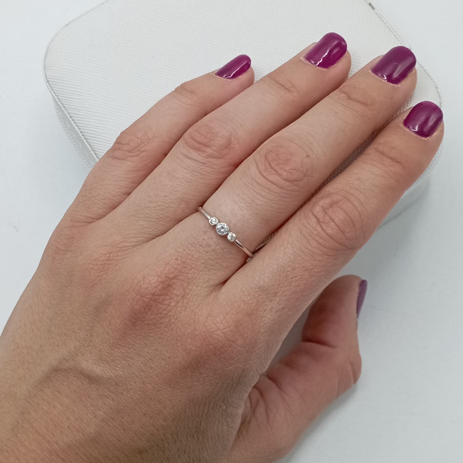 Anillo con circonitas de 2 y 3 mm en plata de ley 925 bañada en rodio, puesto en el dedo