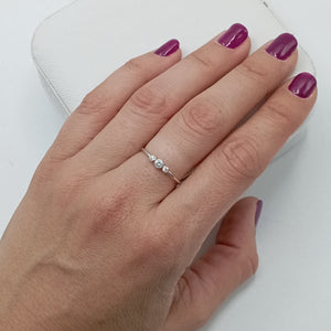 Anillo con circonitas de 2 y 3 mm en plata de ley 925 bañada en rodio, puesto en el dedo
