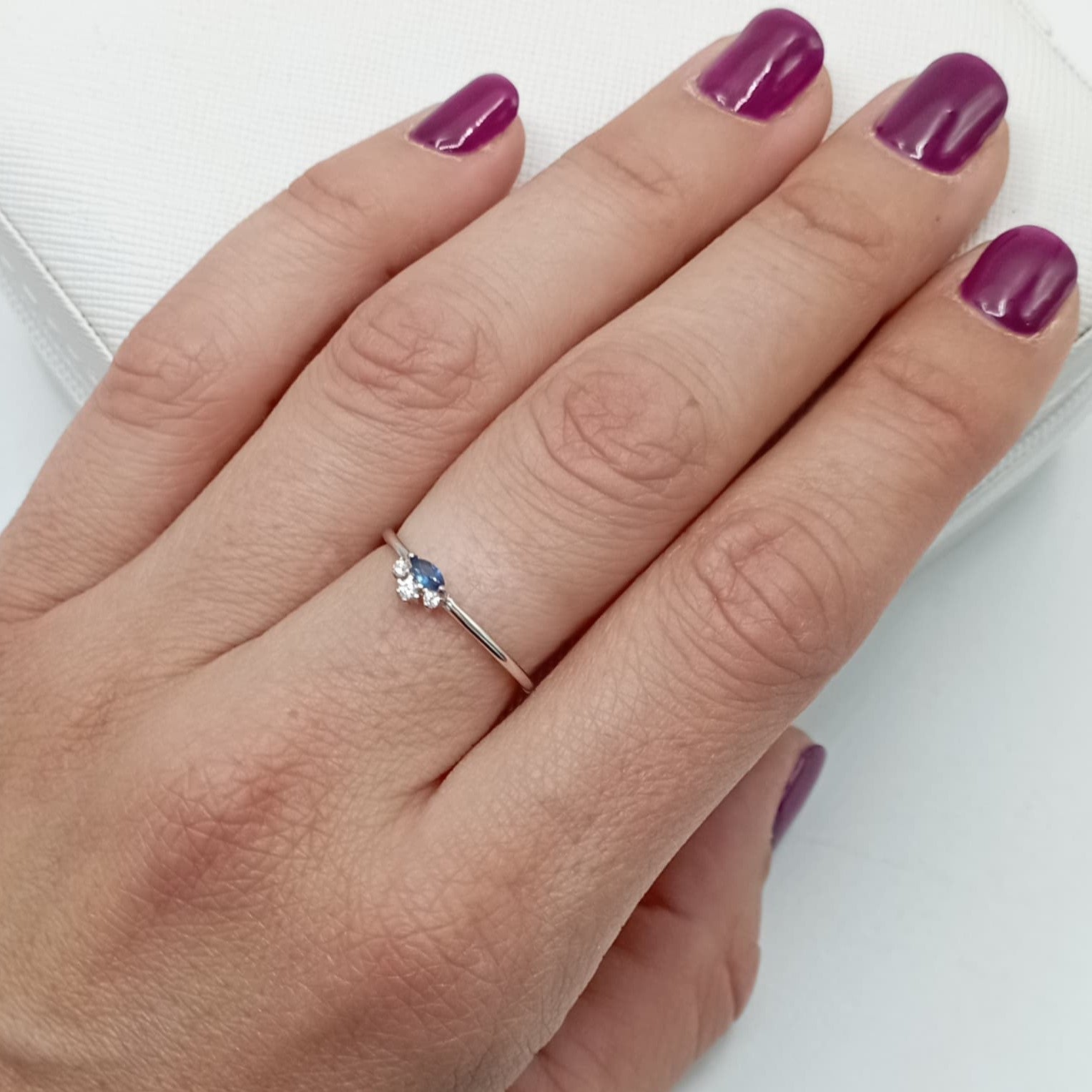 Anillo con circonita azul en plata de ley 925 bañada en rodio, puesto en el dedo