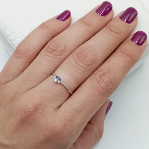 Anillo con circonita azul en plata de ley 925 bañada en rodio, puesto en el dedo