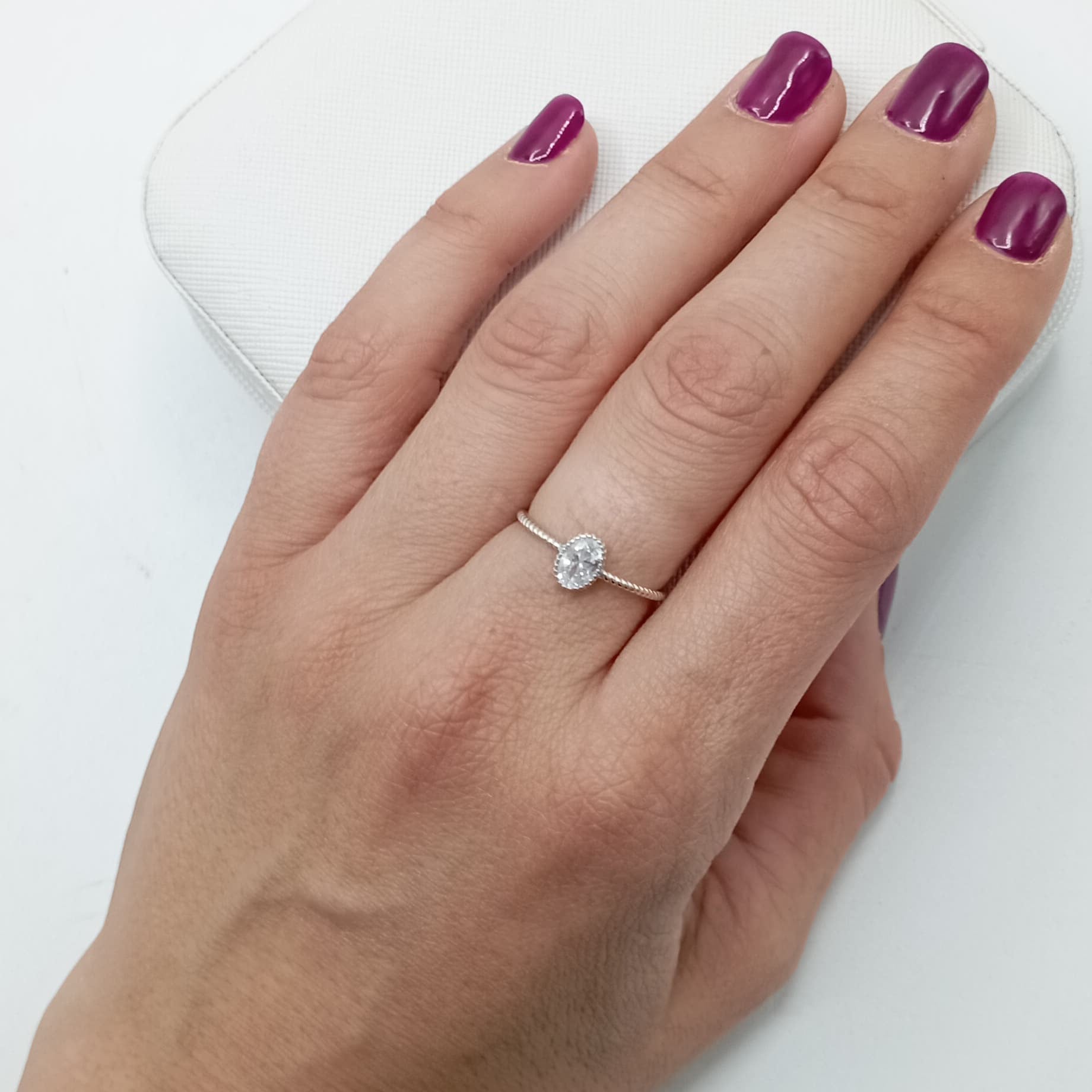 Anillo trenzado con circonitas en plata de ley 925 bañada en rodio, puesto en el dedo