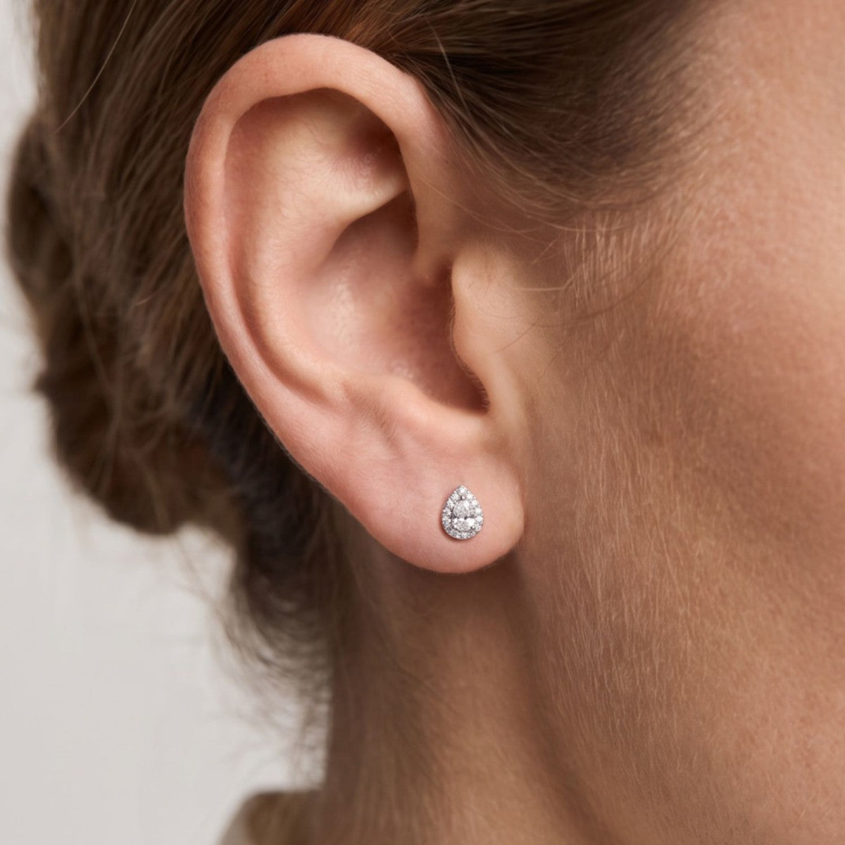 Pendientes gota plata de ley con circonitas blancas puestos en la oreja