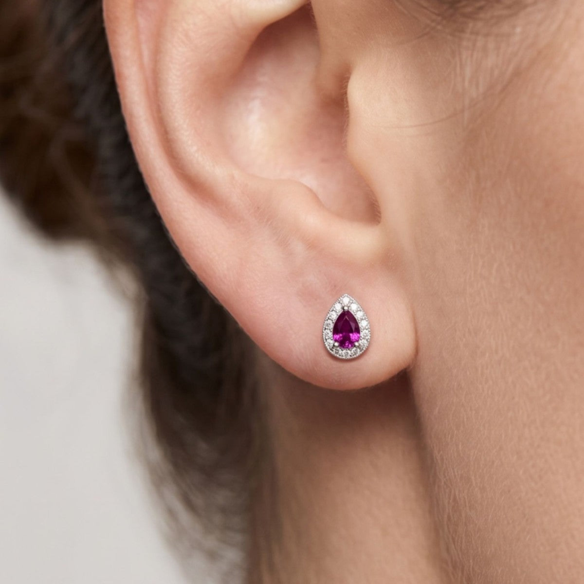 Pendientes gota plata de ley con circonita roja rubí puestos en la oreja