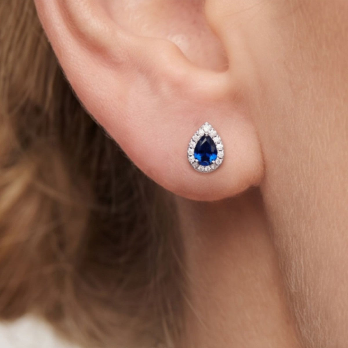 Pendientes gota plata de ley con circonita azul zafiro puestos en la oreja
