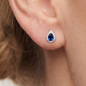 Pendientes gota plata de ley con circonita azul zafiro puestos en la oreja