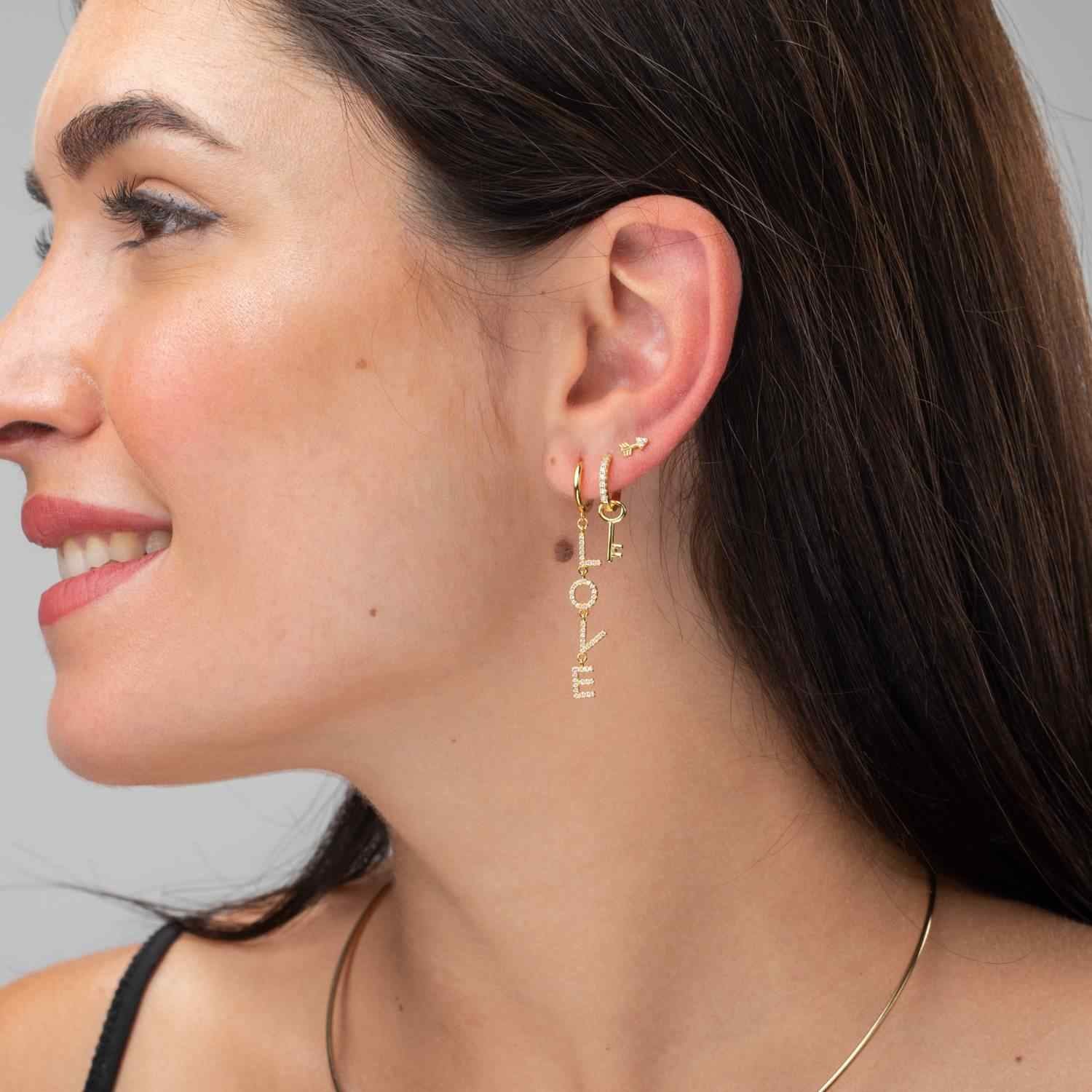 Modelo luciendo pendientes aro love - 11+34 mm - circonita blanca - bañado oro