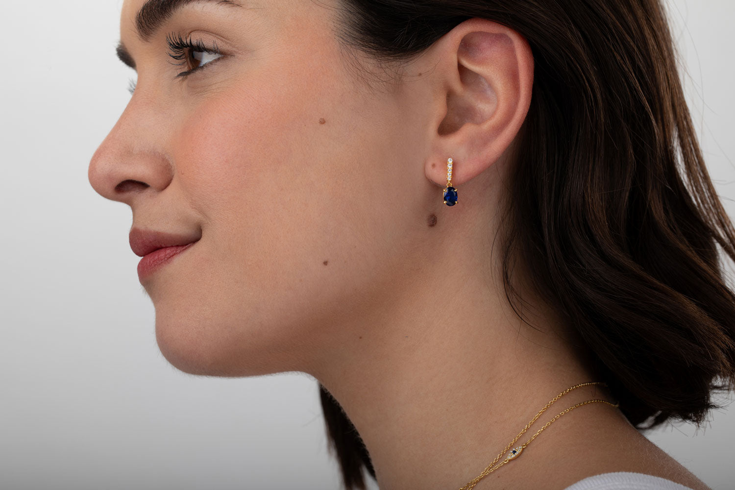 Modelo luciendo pendientes plata - circonita azul 17mm - bañado oro