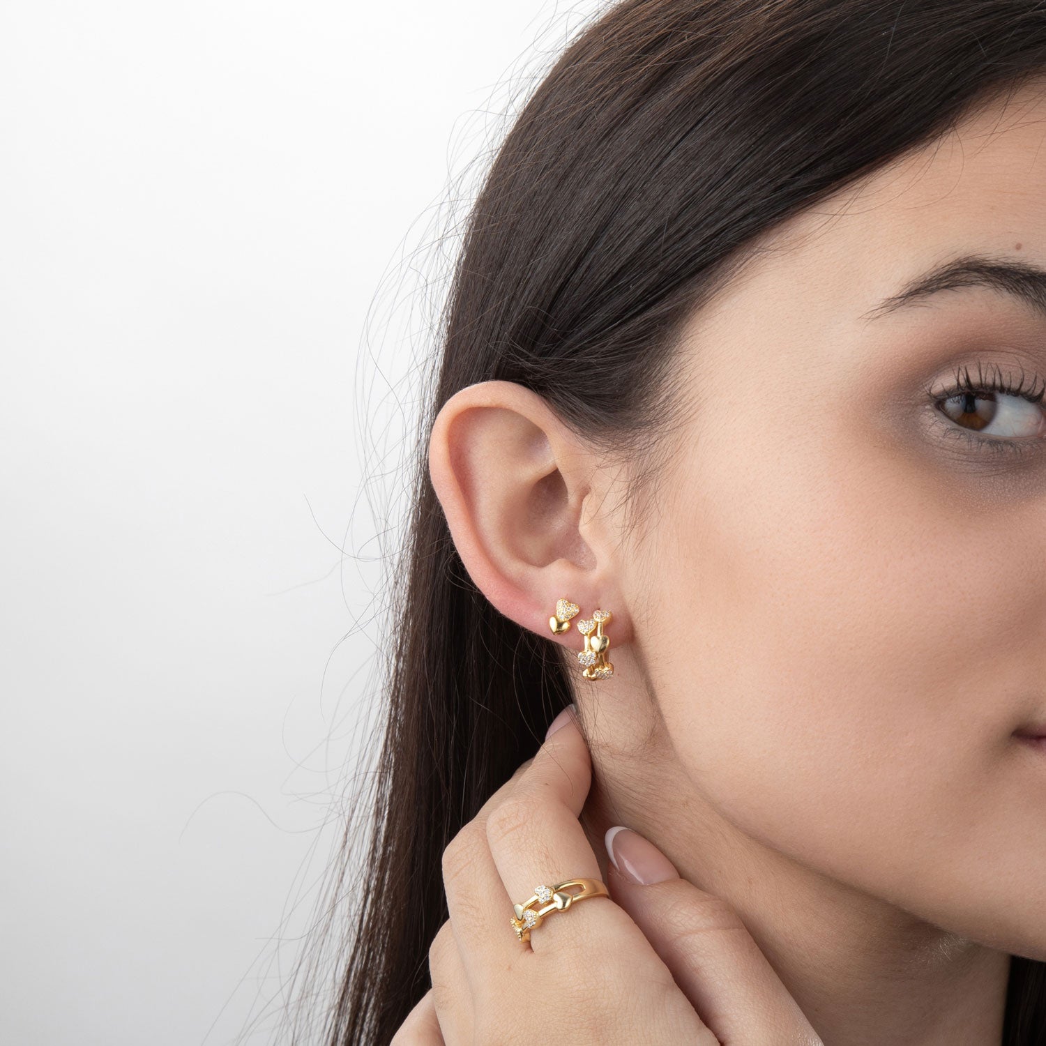 Modelo luciendo pendientes plata circonita - 2 corazones - 8 mm - bañado oro