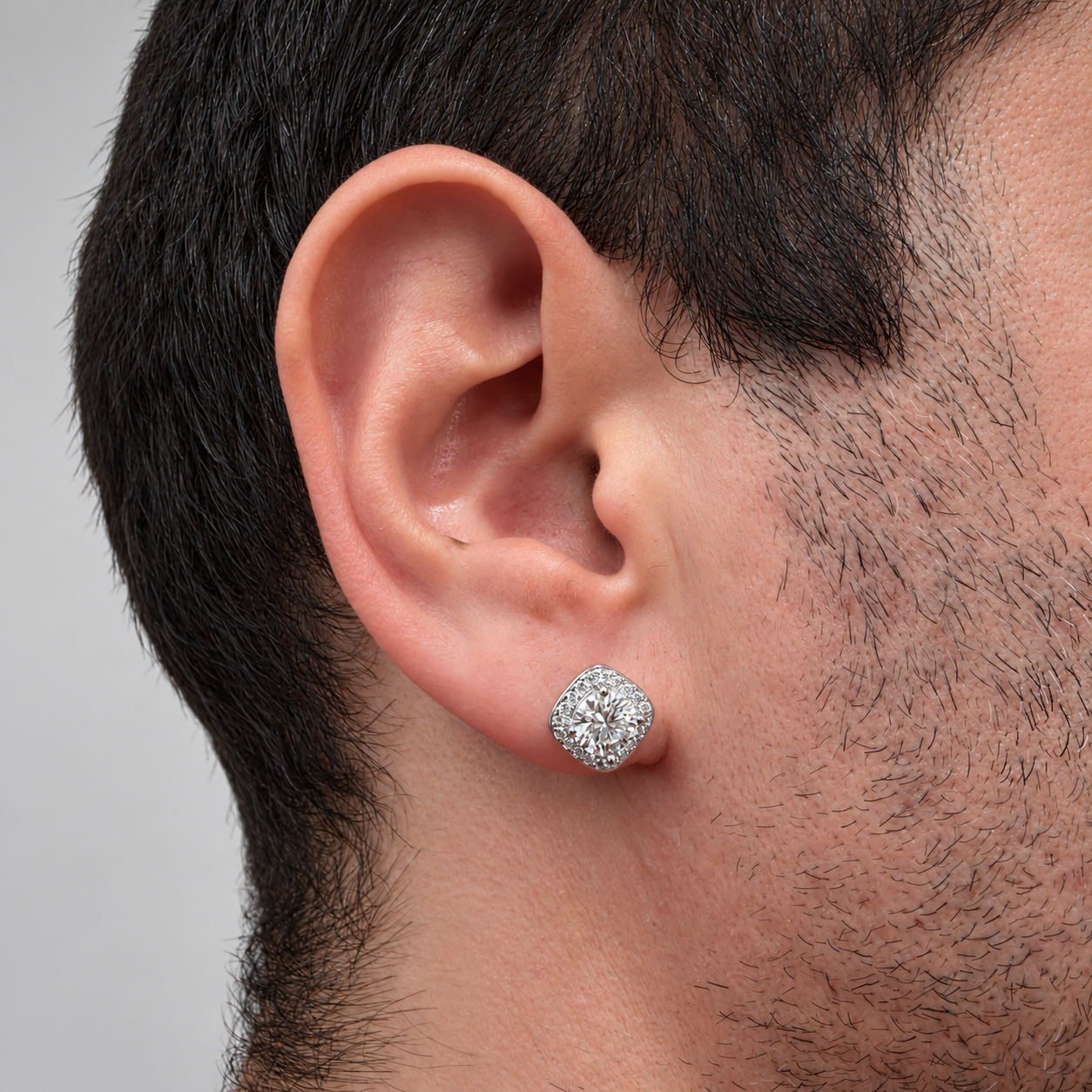 Pendientes de botón con halo de circonitas y moissanita central de 7 mm en plata de ley 925 rodiada puesto en oreja