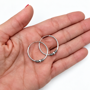 Aros de plata de ley 925 lisos de 24 mm de diámetro sobre la palma de la mano