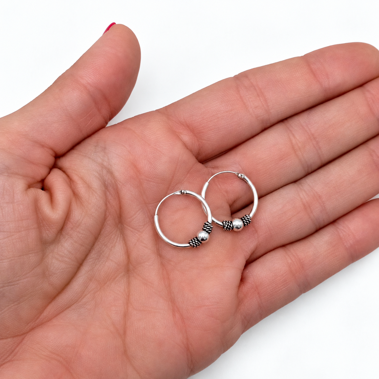 Aros bali de plata de ley 925 oxidados de 16 mm de diámetro sobre la palma de la mano