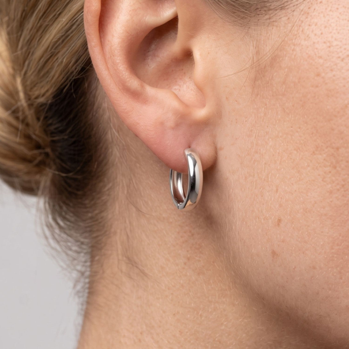 Criolla de plata de ley 925 lisa de 4 mm de ancho y 15 mm de alto puesta en la oreja