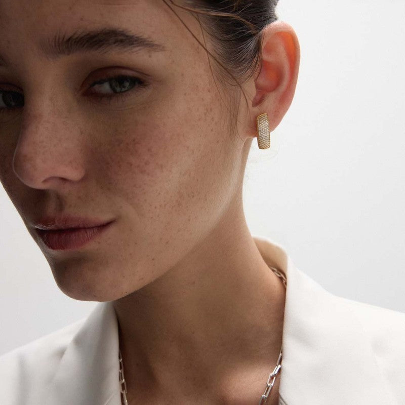 Pendiente de aro oval de plata de ley 925 bañada en oro 18k con circonitas en pavé, puesto en la oreja