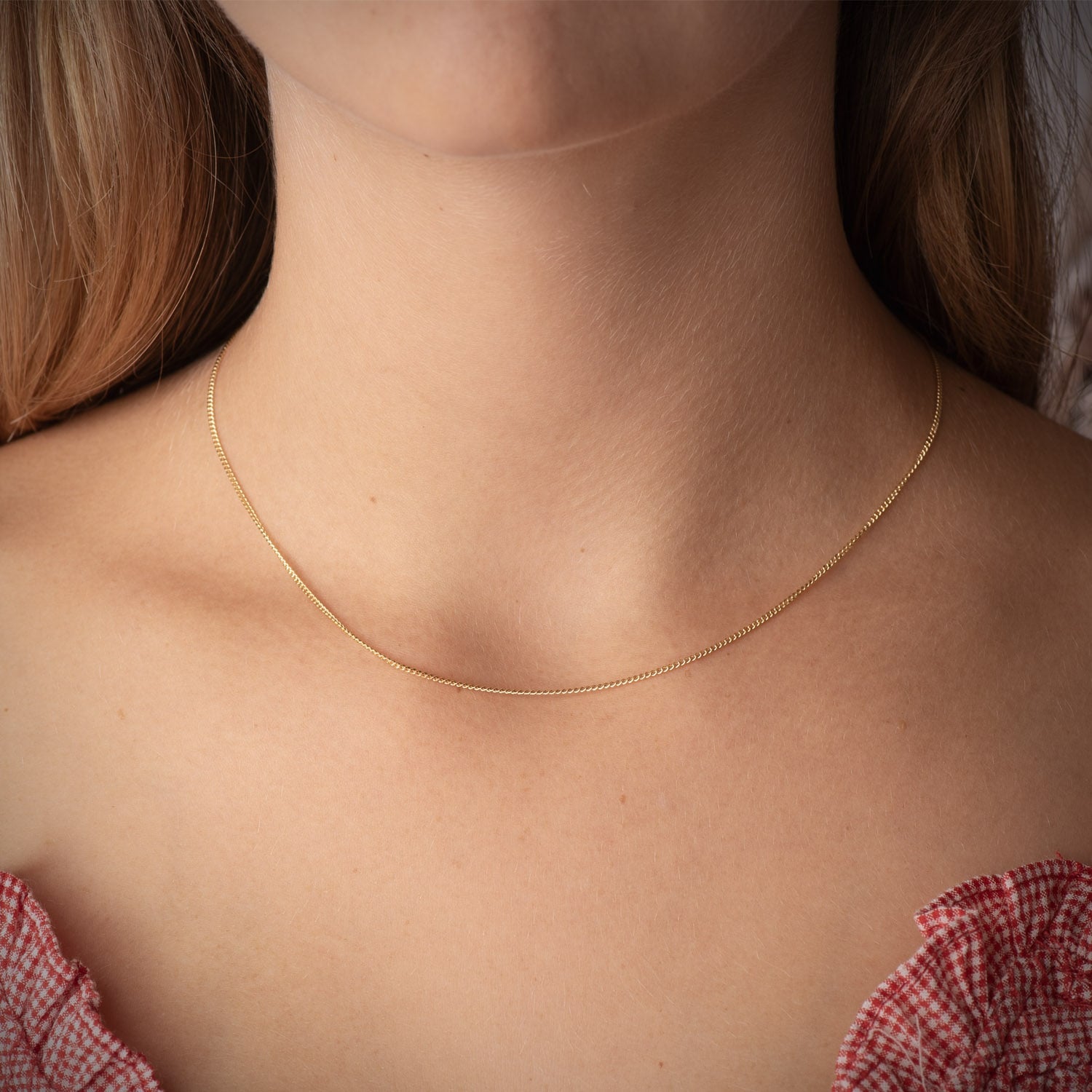 Cadena de oro 18k barbada maciza de 1 mm puesta al cuello