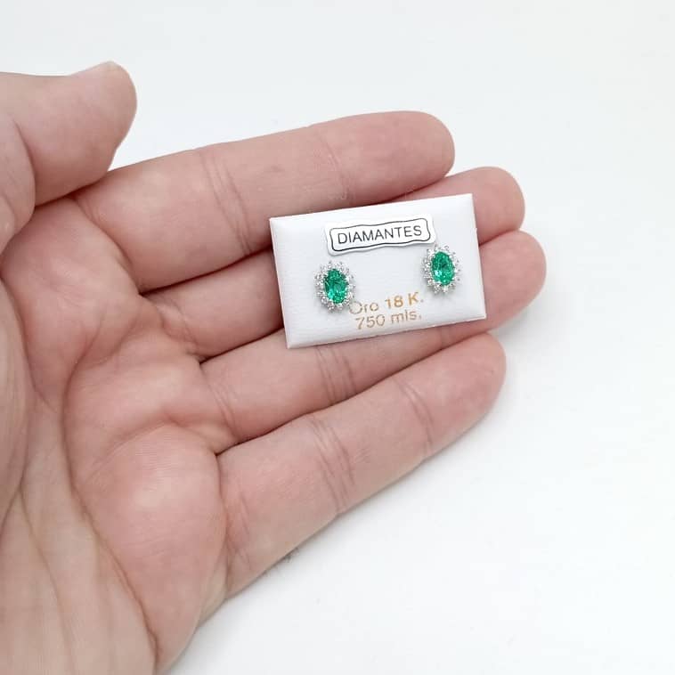 Par de pendientes pequeños oro blanco con una esmeralda y cerco de diamantes foto