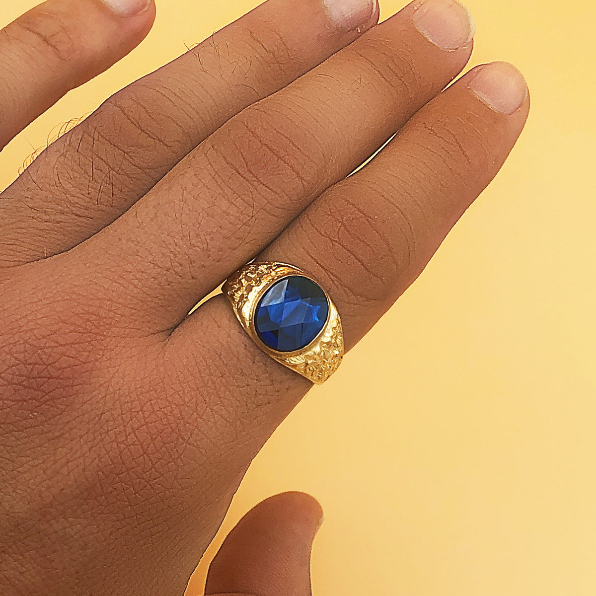 Detalle de sello cadete de oro de ley 18k macizo con piedra spinel azul zafiro oval de 12x10 mm
