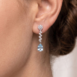 Pendientes zigzag plata de ley con circonitas blancas y aguamarina puestos en la oreja