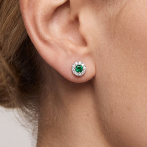 Pendientes círculo plata de ley con circonita verde esmeralda puestos en la oreja