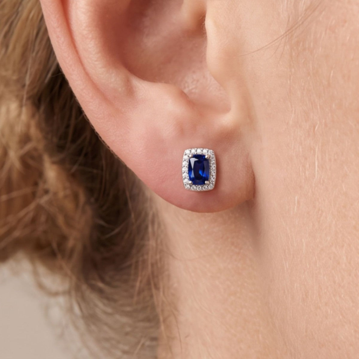 Pendientes cuadrado plata de ley con circonita azul zafiro puestos en la oreja