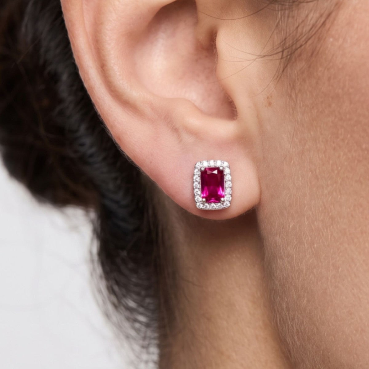 Pendientes cuadrado plata de ley con circonita roja rubí puestos en la oreja