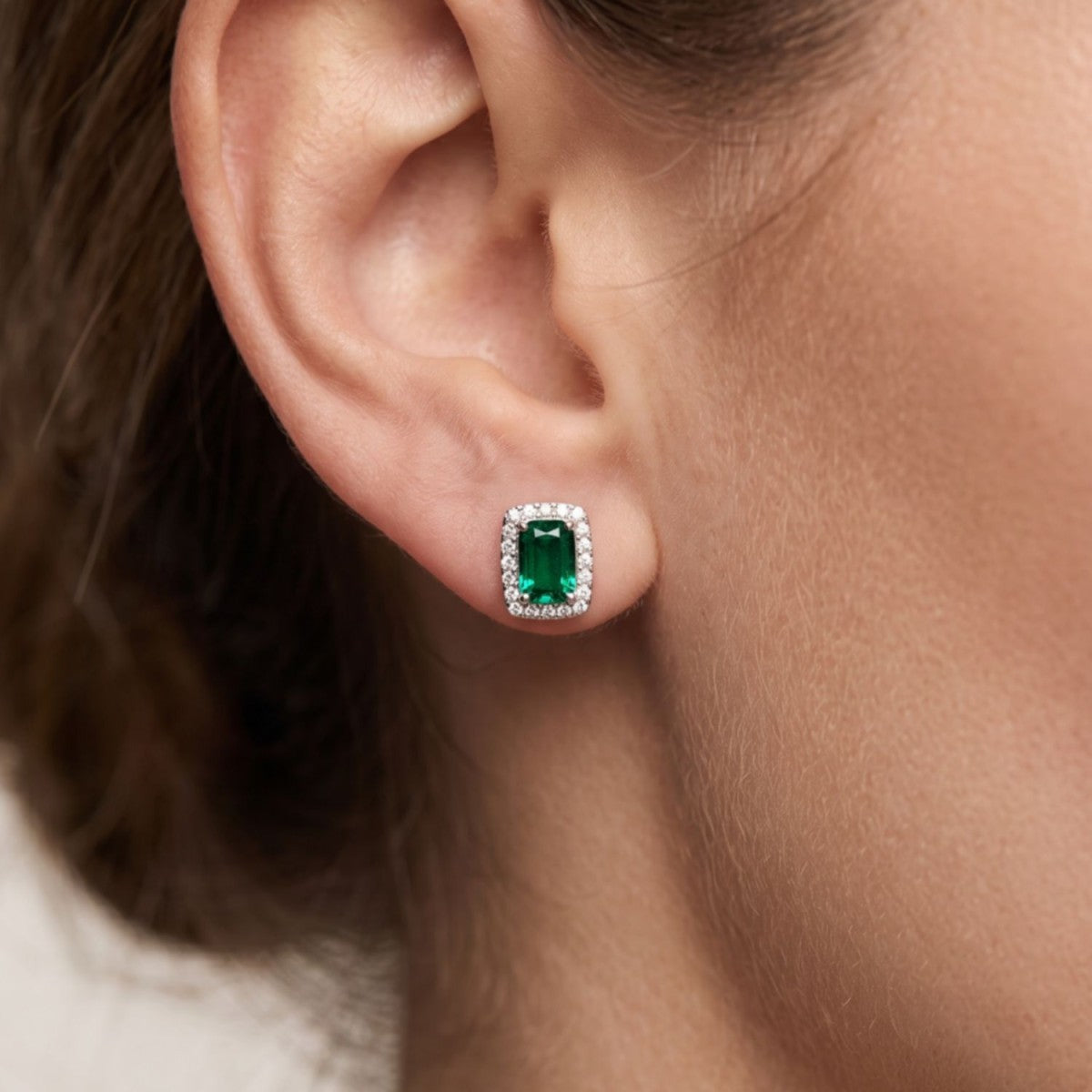Pendientes cuadrado plata de ley con circonita verde esmeralda puestos en la oreja