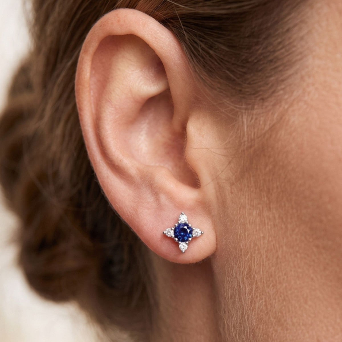 Pendientes tulipán plata de ley con circonita azul zafiro puestos en la oreja