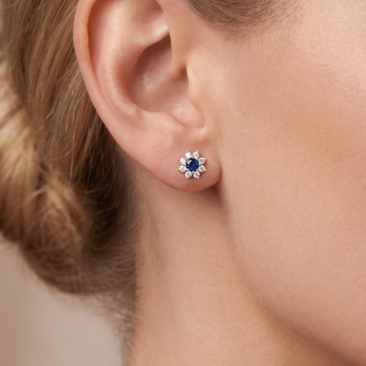 Pendientes estrella plata de ley con circonita azul zafiro puestos en la oreja
