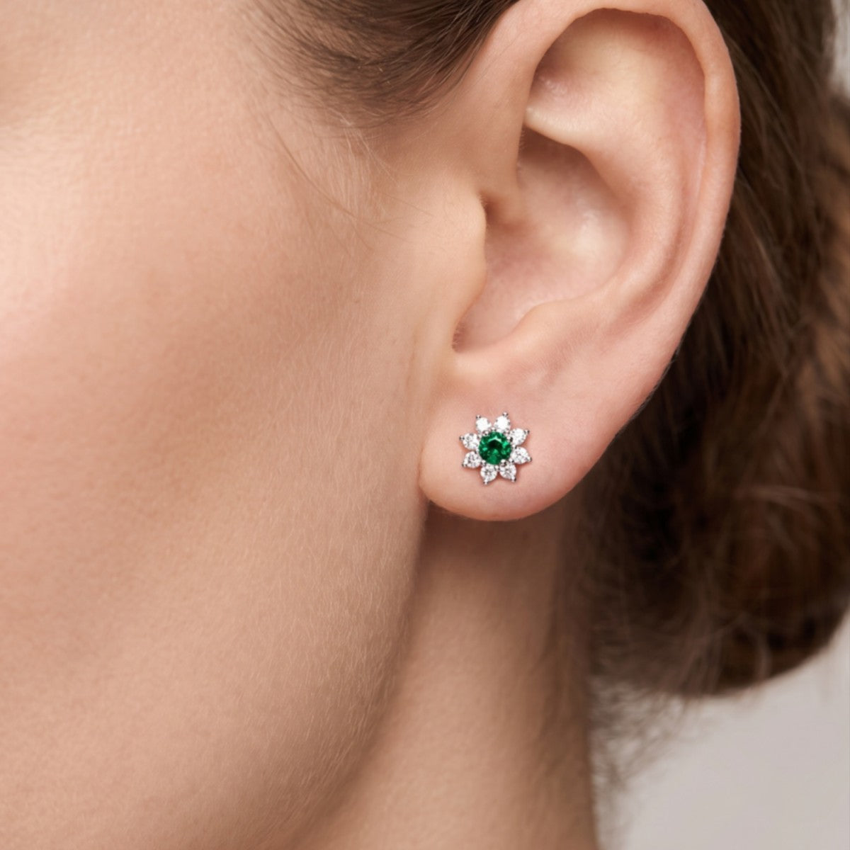 Pendientes estrella plata de ley con circonita verde esmeralda puestos en la oreja