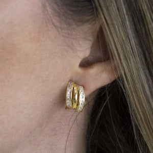 chica con Pendientes de plata 925 chapada en oro con tres aros y banda de circonitas. Cierre omega. Diseño elegante.