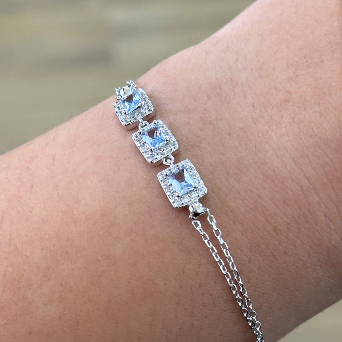 Pulsera de plata de ley 925 con tres circonitas color aguamarina y orla de blancas
