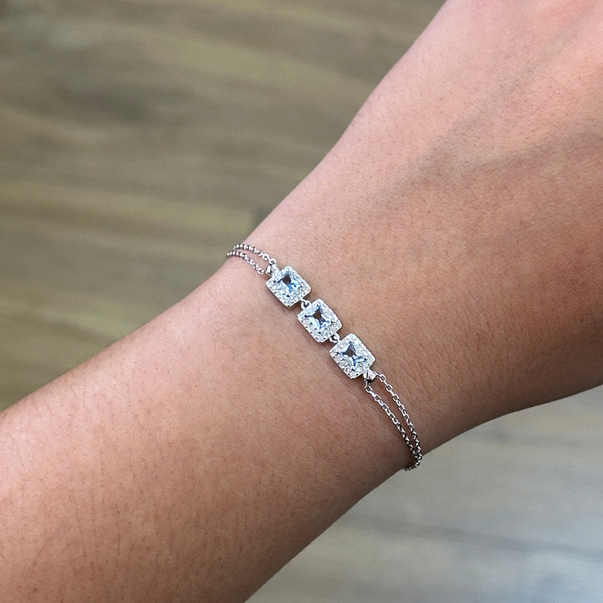 Pulsera de plata de ley 925 con tres circonitas color aguamarina y orla de blancas