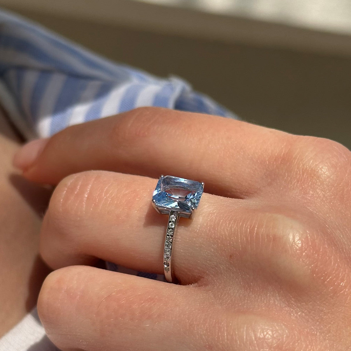 Anillo de Plata de Ley con circonitas blancas y circonita central en color aguamarina foto