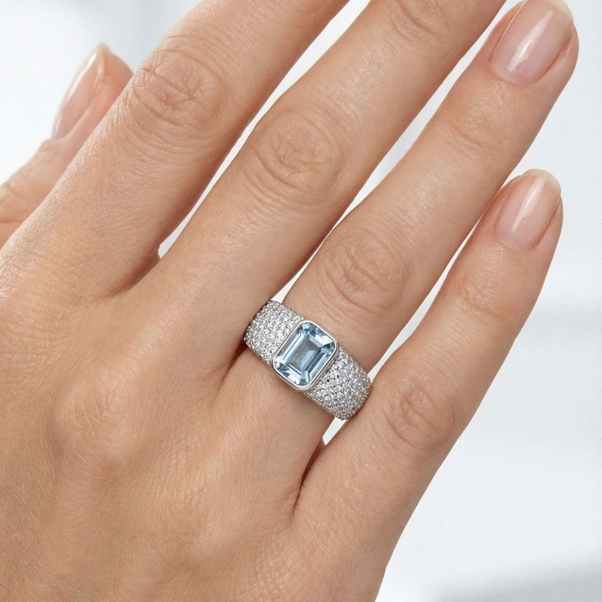 Anillo de plata de ley 925 con varias circonitas color aguamarina y brazo cuajado