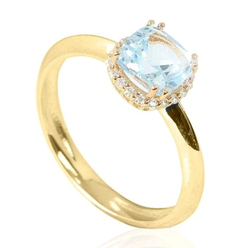 Sortija de oro amarillo de 18 k con orla de circonitas y un topacio azul en el centro engastado en garras